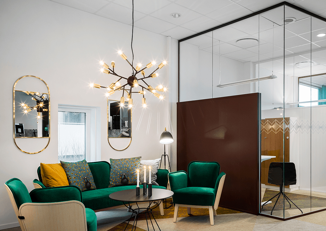 Kontorlokaler med glasvægge, mørkegrøn sofagruppe og symbol for årets kontor 2019 ifølge Newst