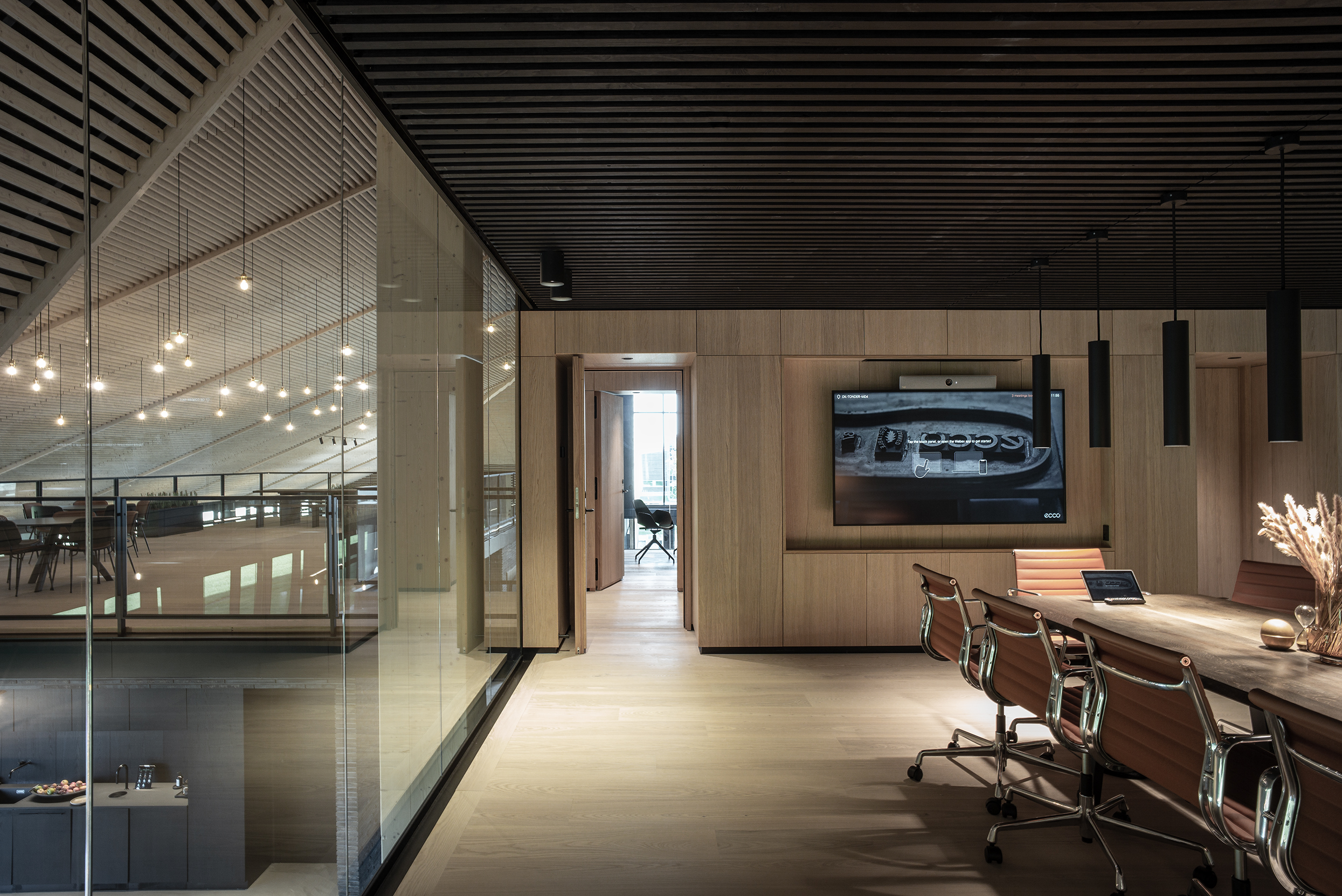 Stort mødelokale med transparente væge og sort træbeklædt loft