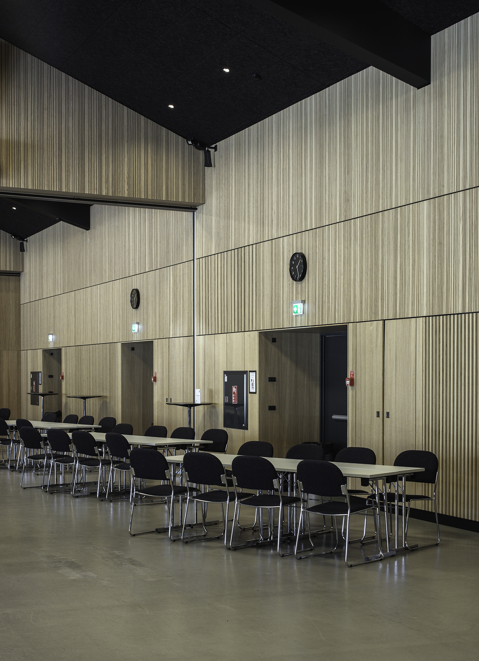 Konfrerencelokale med sorte møbler og stripe paneler på vægge